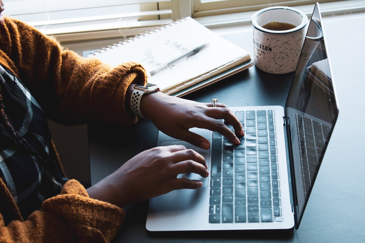 Person typing on a desk at home